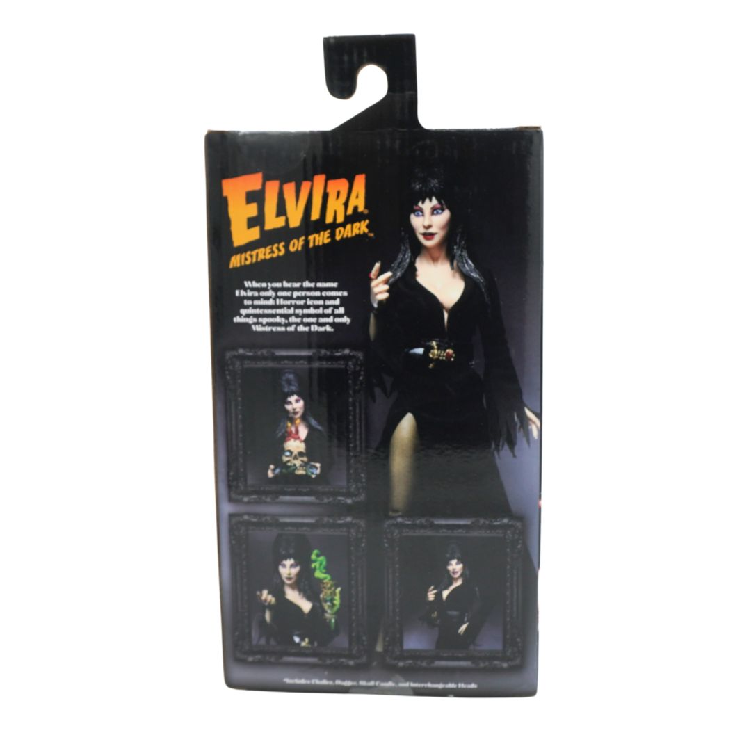 Elvira 'Mistress of the Dark' action figure in its original retail packaging, featuring a black dress and accessories, with character art and product descriptions on the box.