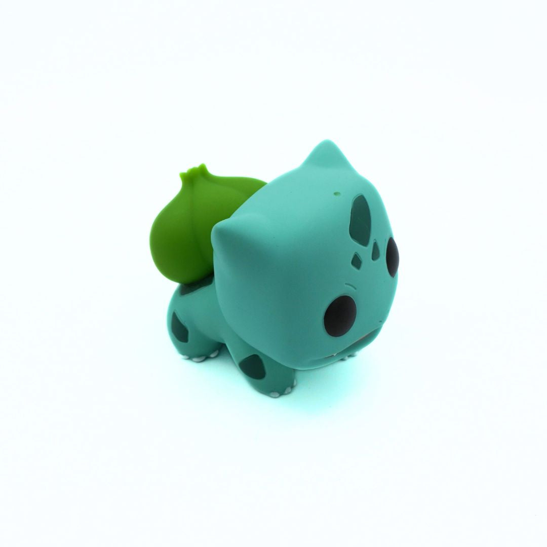 Green toy figure of a character with a leaf on a white background