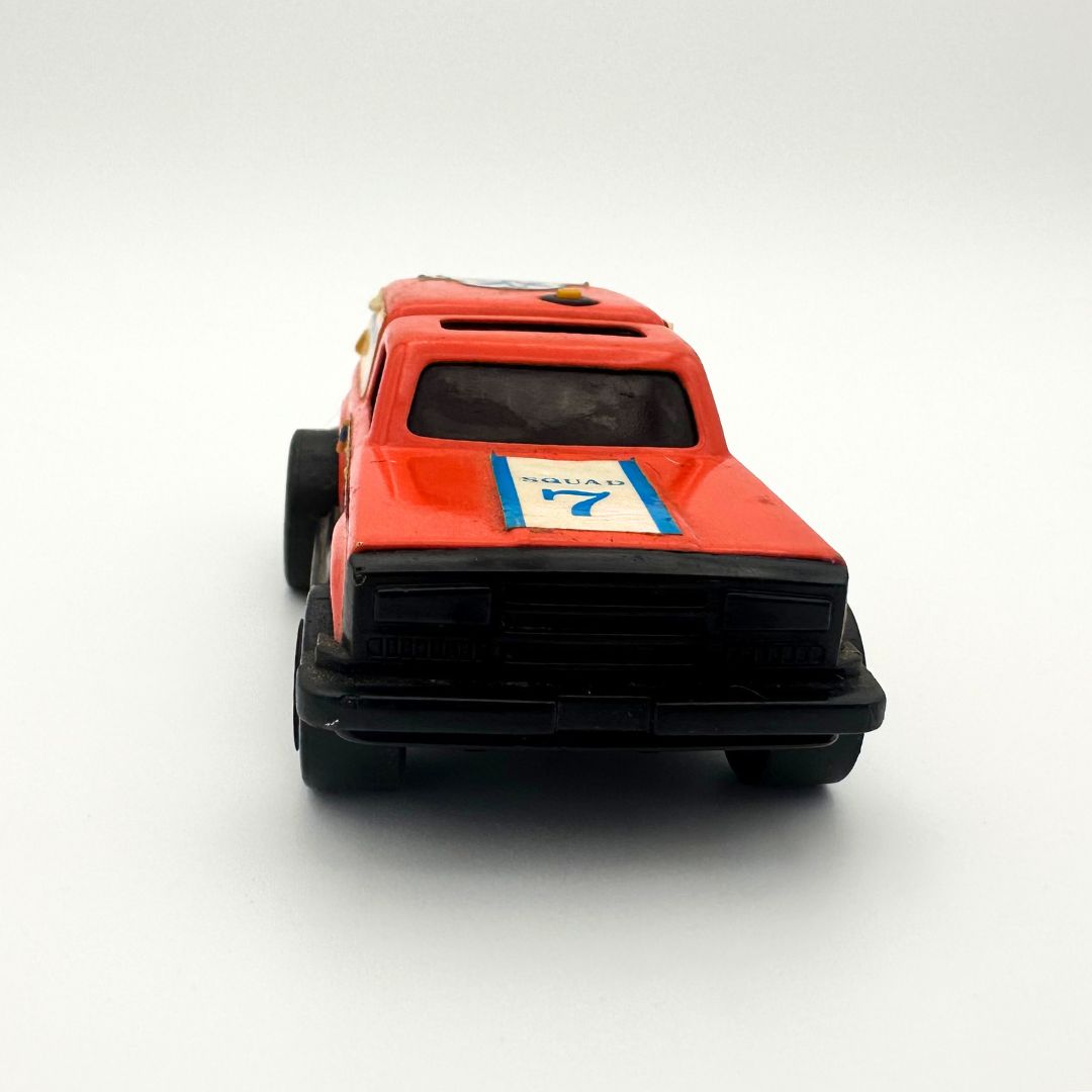 An orange-red die-cast toy car