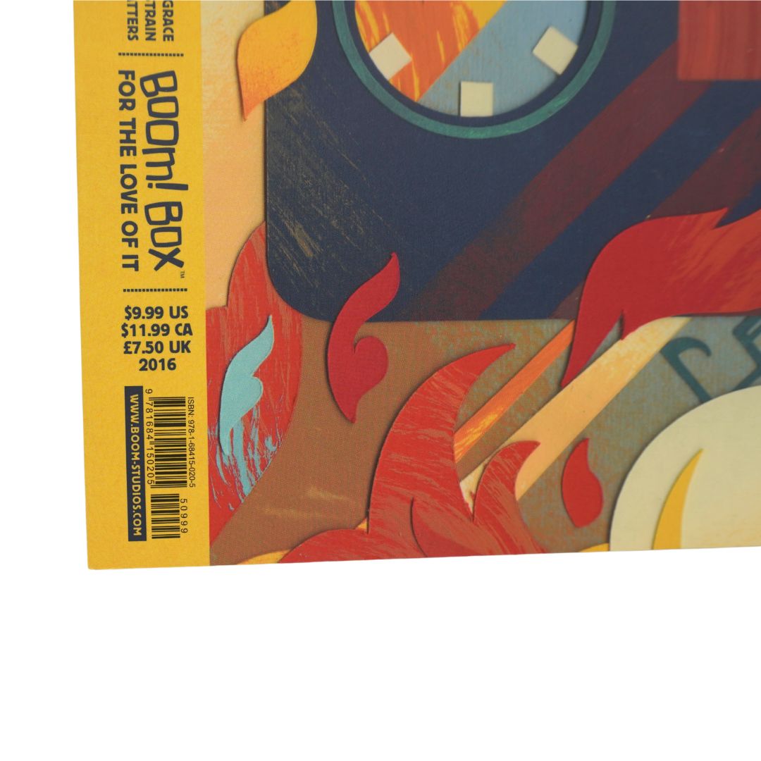 A close-up of a comic book cover or booklet spine showing the title 'Boom! Box' and pricing text, with an abstract multicolor illustration in yellow, red, blue, orange, and brown.