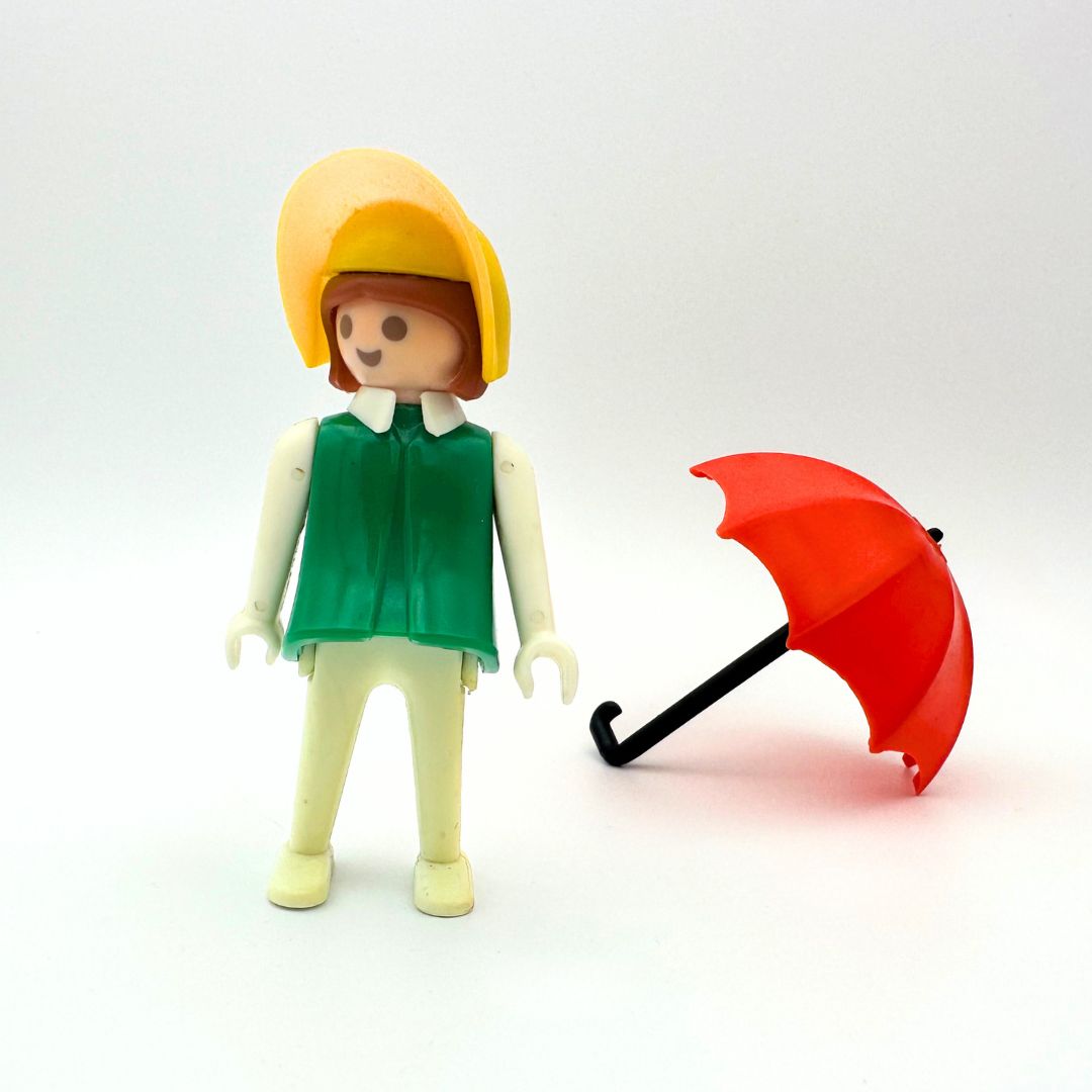 A 1974 Geobra doll with a red umbrella accessory in excellent condition