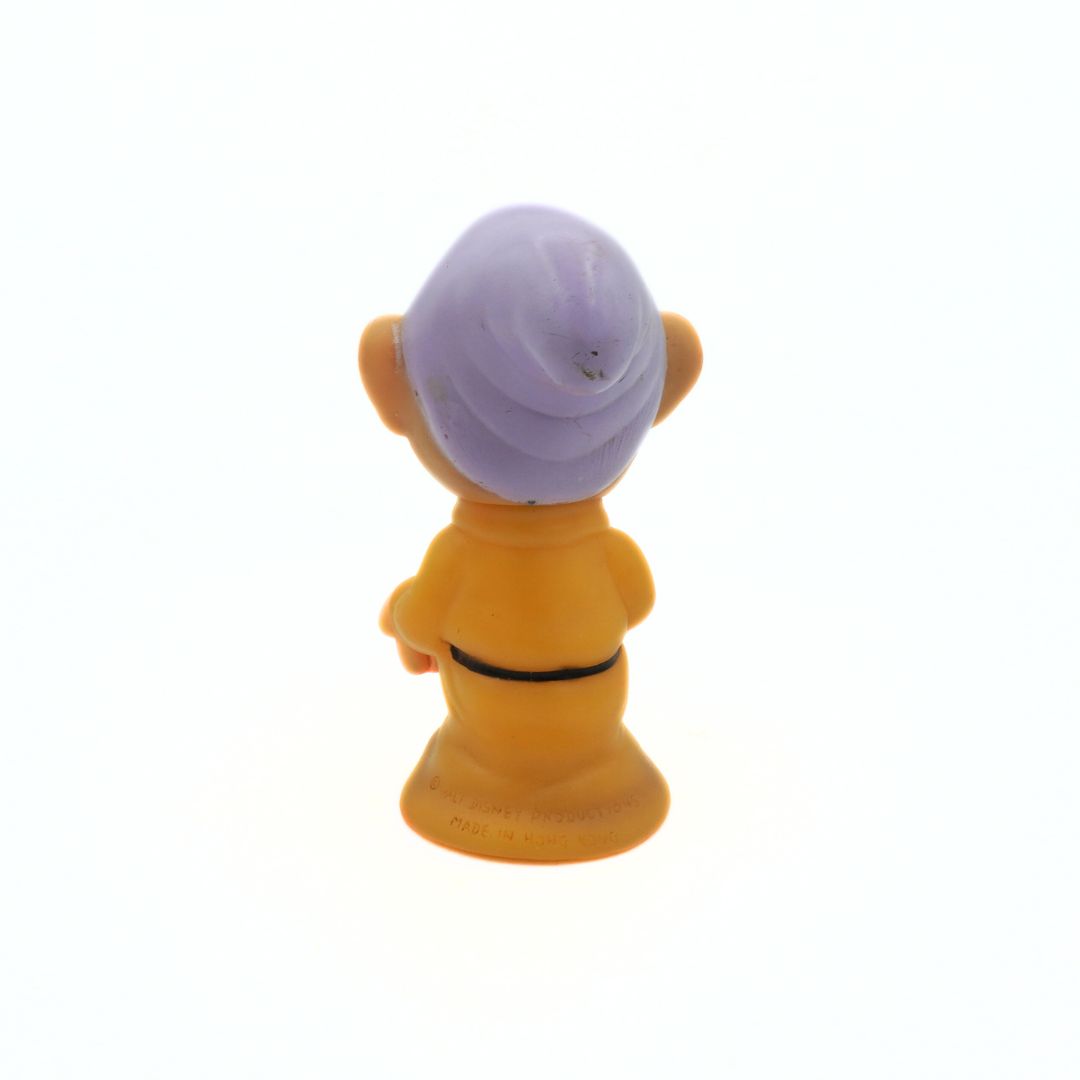 Small figurine with a purple hat on a white background