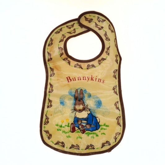 Baby bib with rabbit design and 'Bunnykins' text on a beige background