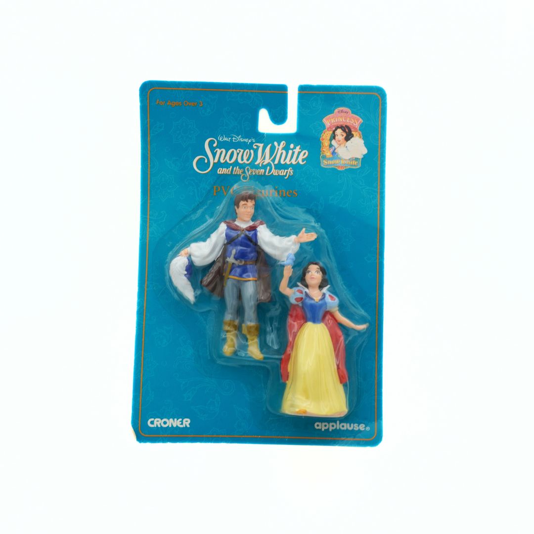 Action figures of Snow White and Prince Charming in packaging with Disney branding.
