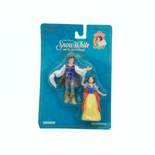 Action figures of Snow White and Prince Charming in packaging with Disney branding.