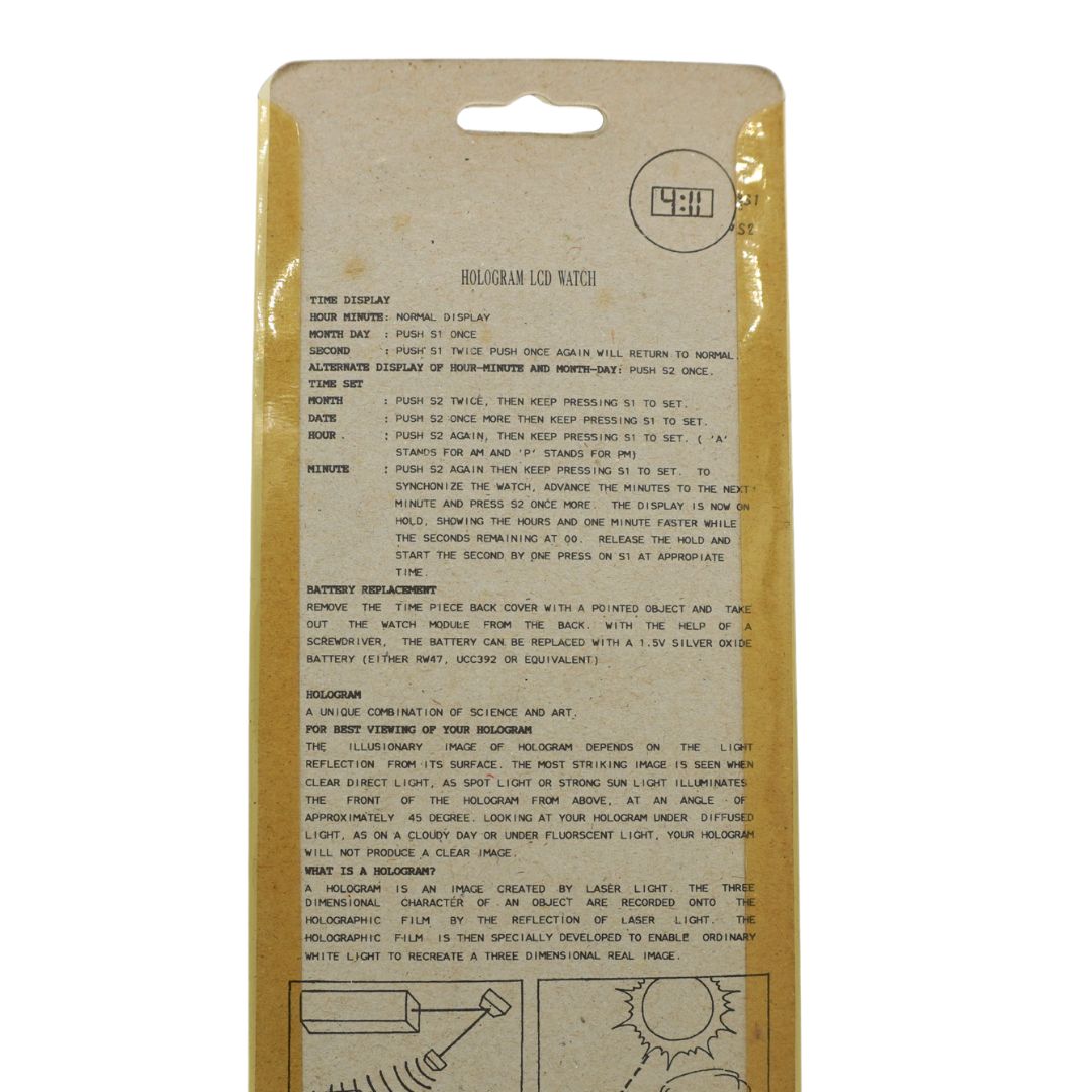 The back of a vointage 90s dinosaur watch on brown cardboard