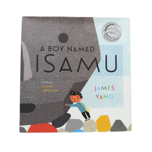 The book cover of 'A Boy Named Isamu' by James Yang, featuring a minimalist illustration of a boy pushing a large gray boulder, with colorful accents on a white background.