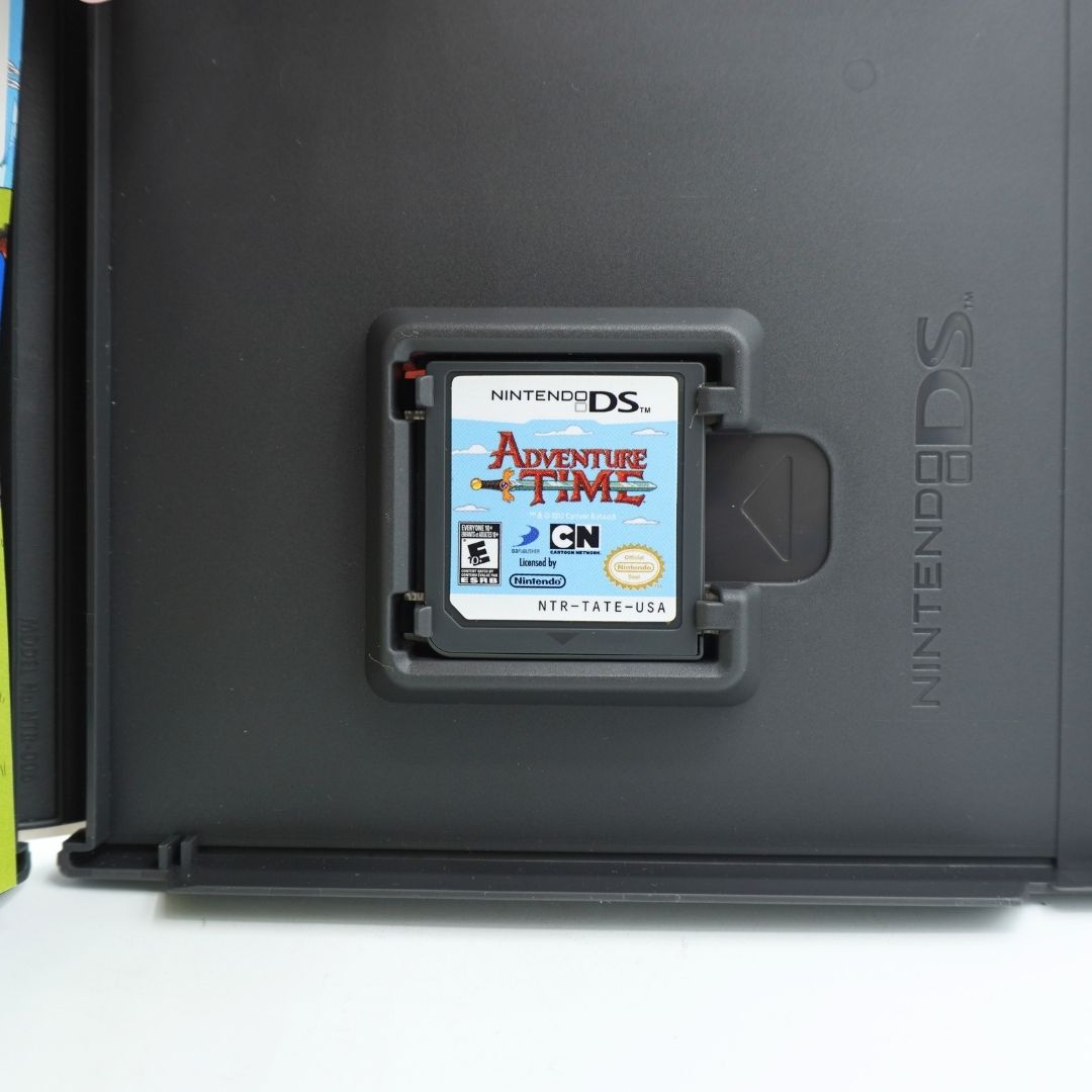 Nintendo DS Adventure Time game cartridge inserted into a black Nintendo DS console, shown close-up against a dark plastic housing.