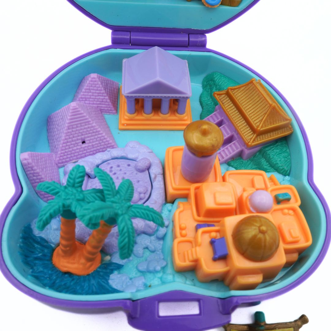 Toy set with pyramids, palm trees, and other structures in a purple toy box.