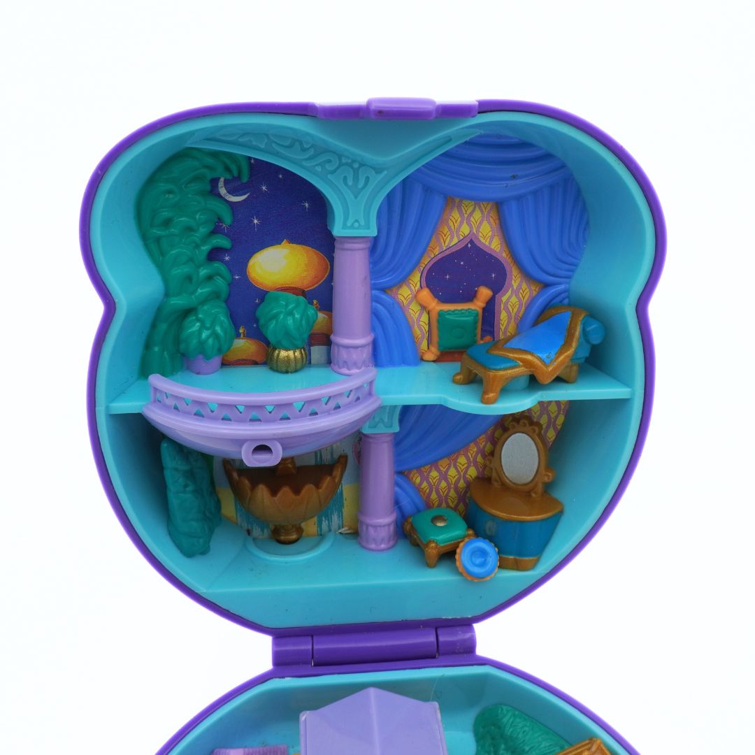 Toy set with miniature furniture and decorations inside a blue and purple toy box on a white background