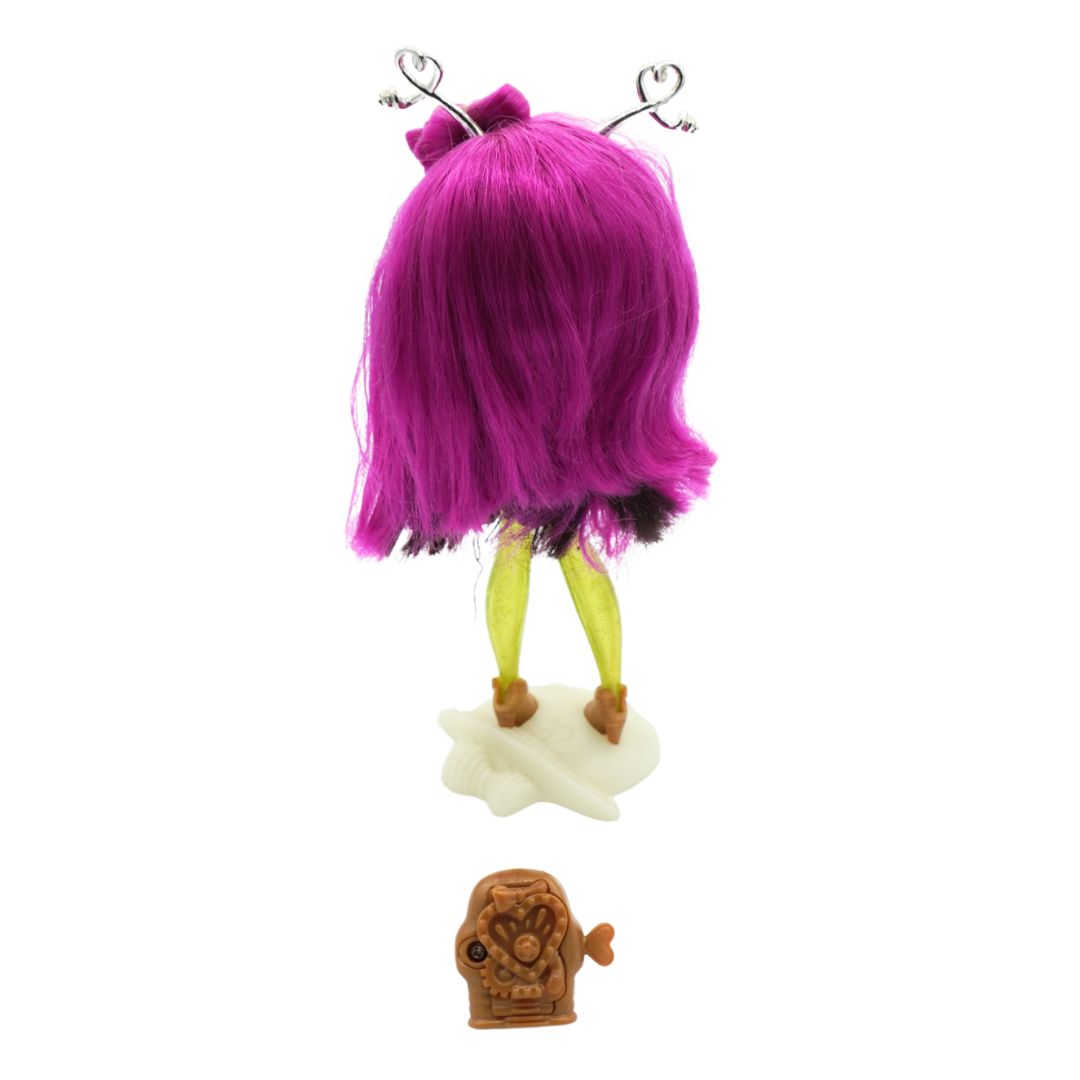 A Novi Star doll with green legs and purple hair, wearing a dark denim dress and standing on a cream coloured stand