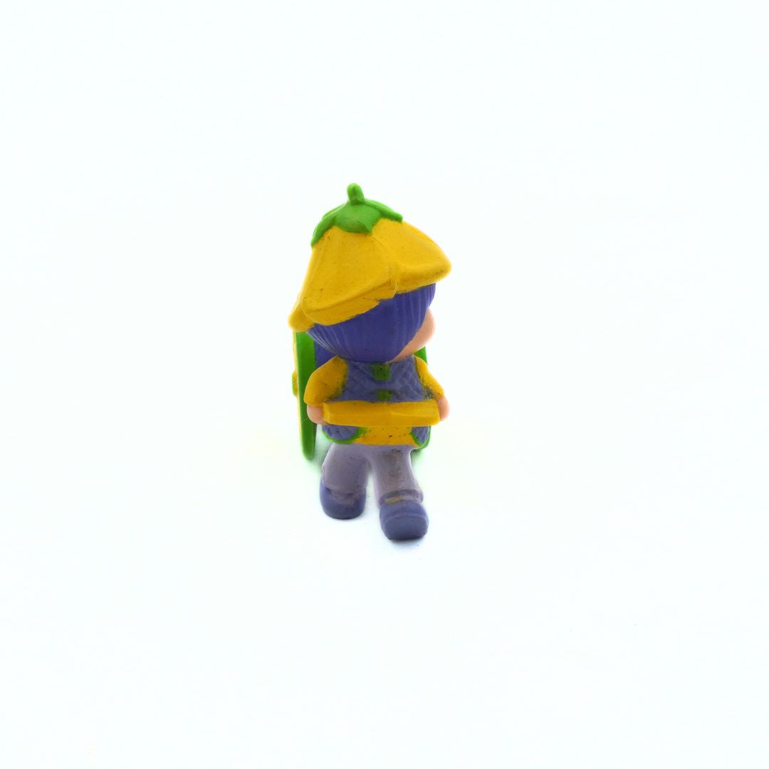 Small figurine with a yellow hat and backpack on a white background