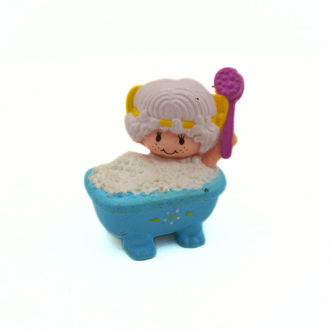 Toy figure of a character with white hair and a blue bathtub on a white background