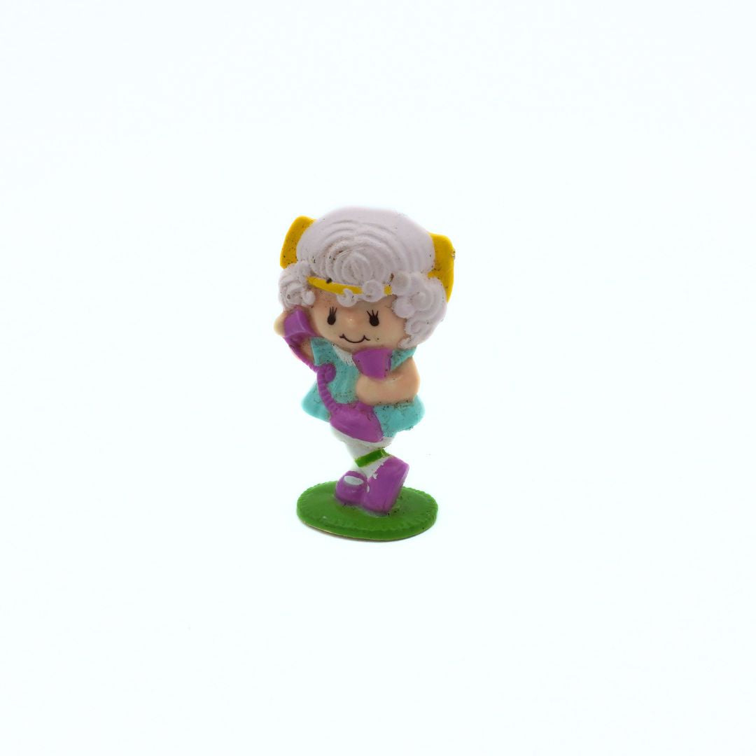Toy figure with colorful outfit and white hair on a white background