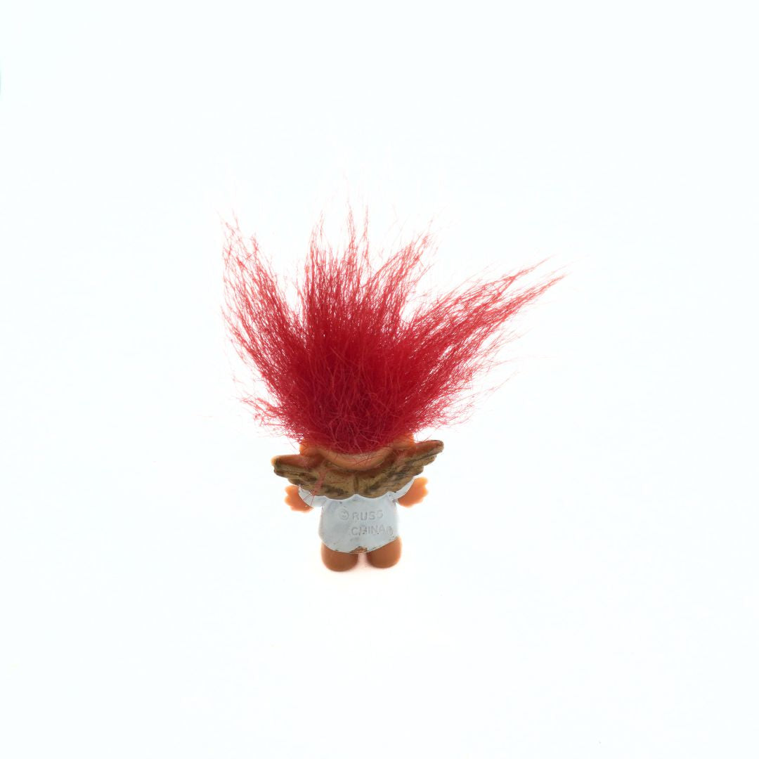 Small figurine with red hair on a white background