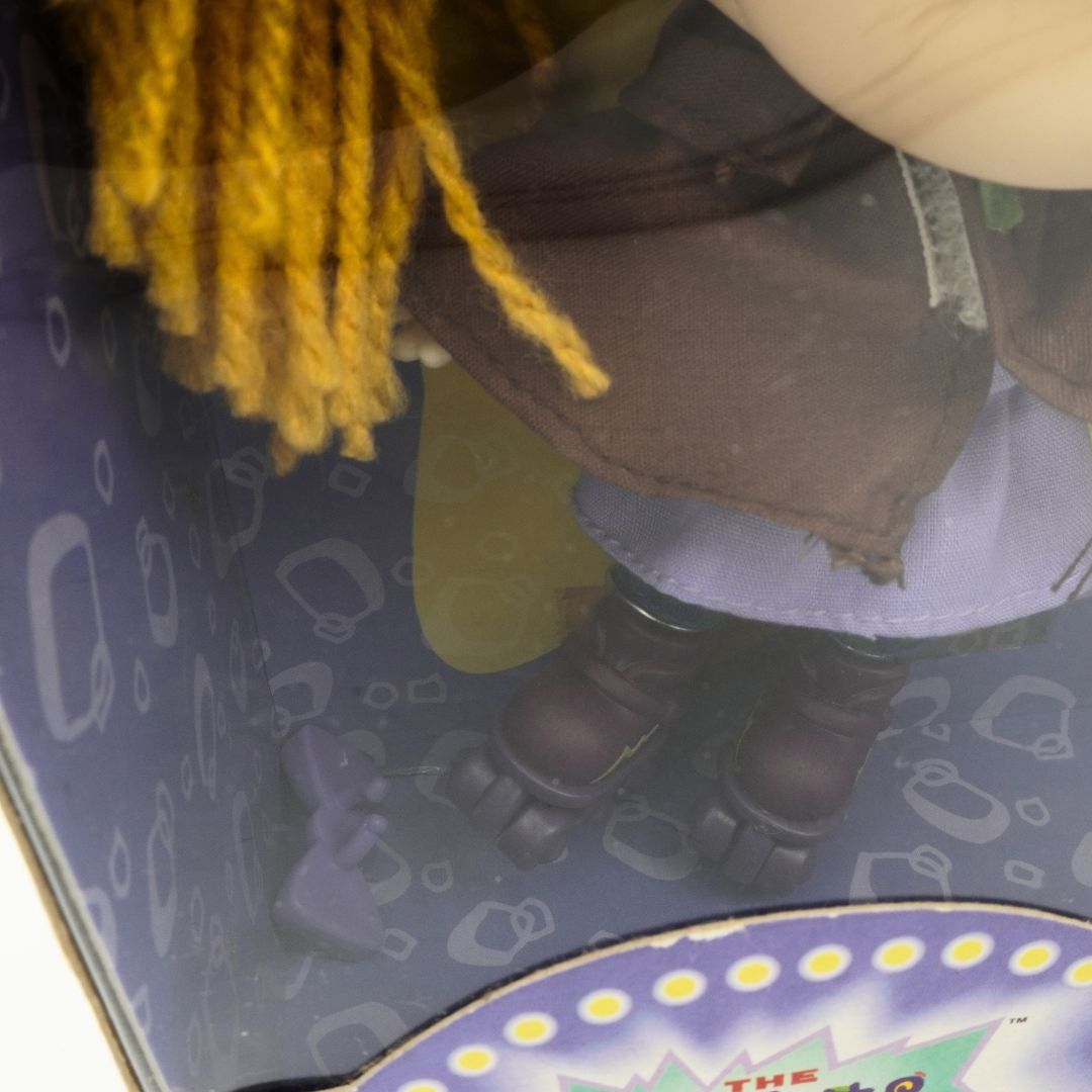 Pigtail bow at the base of a Rugrats Angelica doll that has fallen from a pigtail