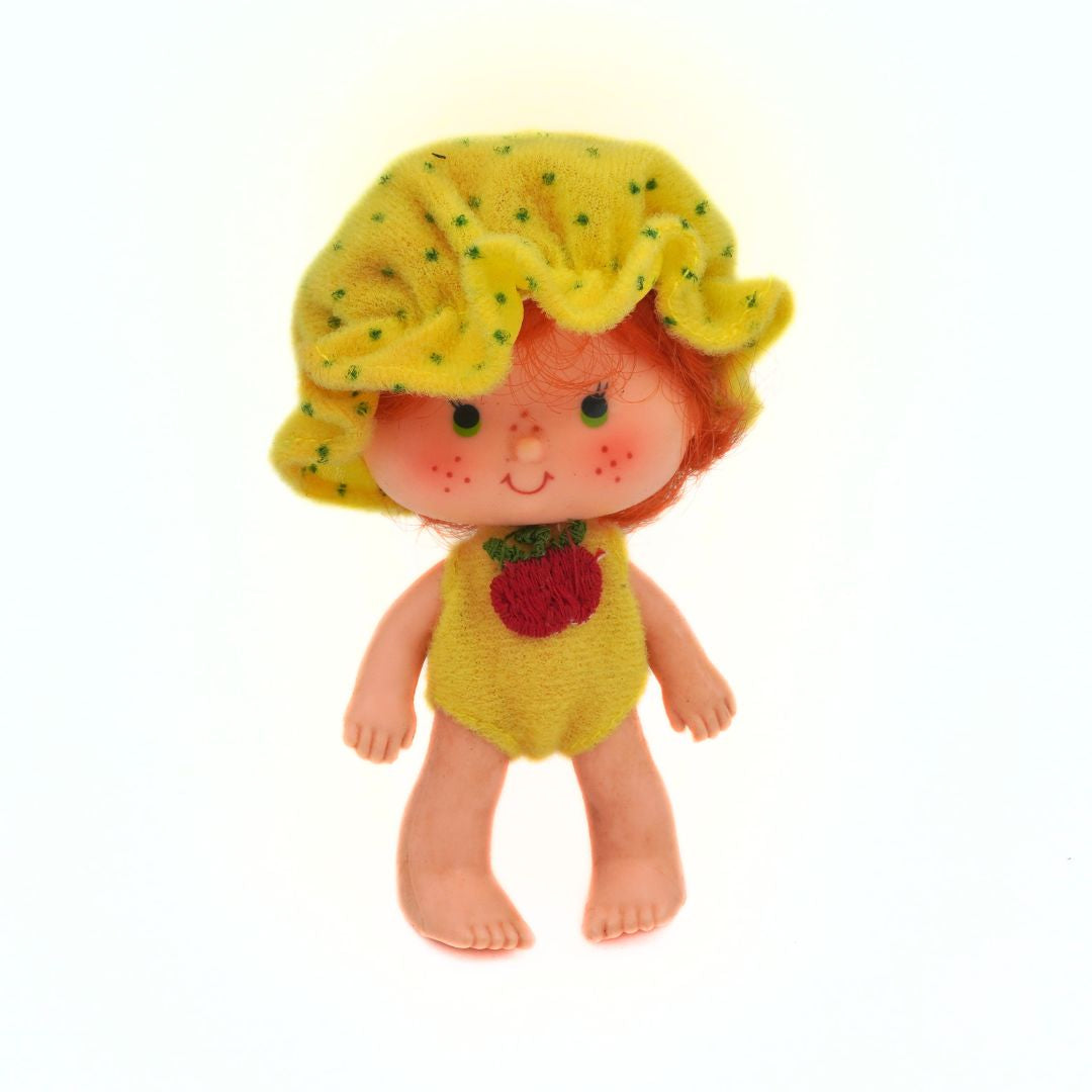 Toy figure with a yellow outfit and hat on a white background