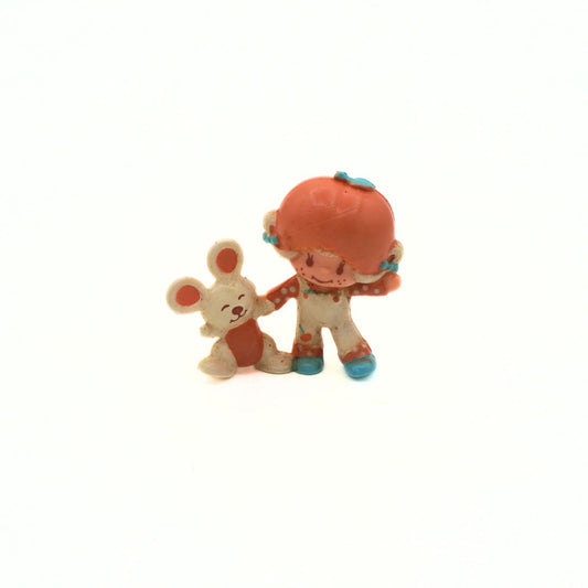 Two small figurines, one resembling a bunny and the other a character with an orange head and blue shoes, on a white background.