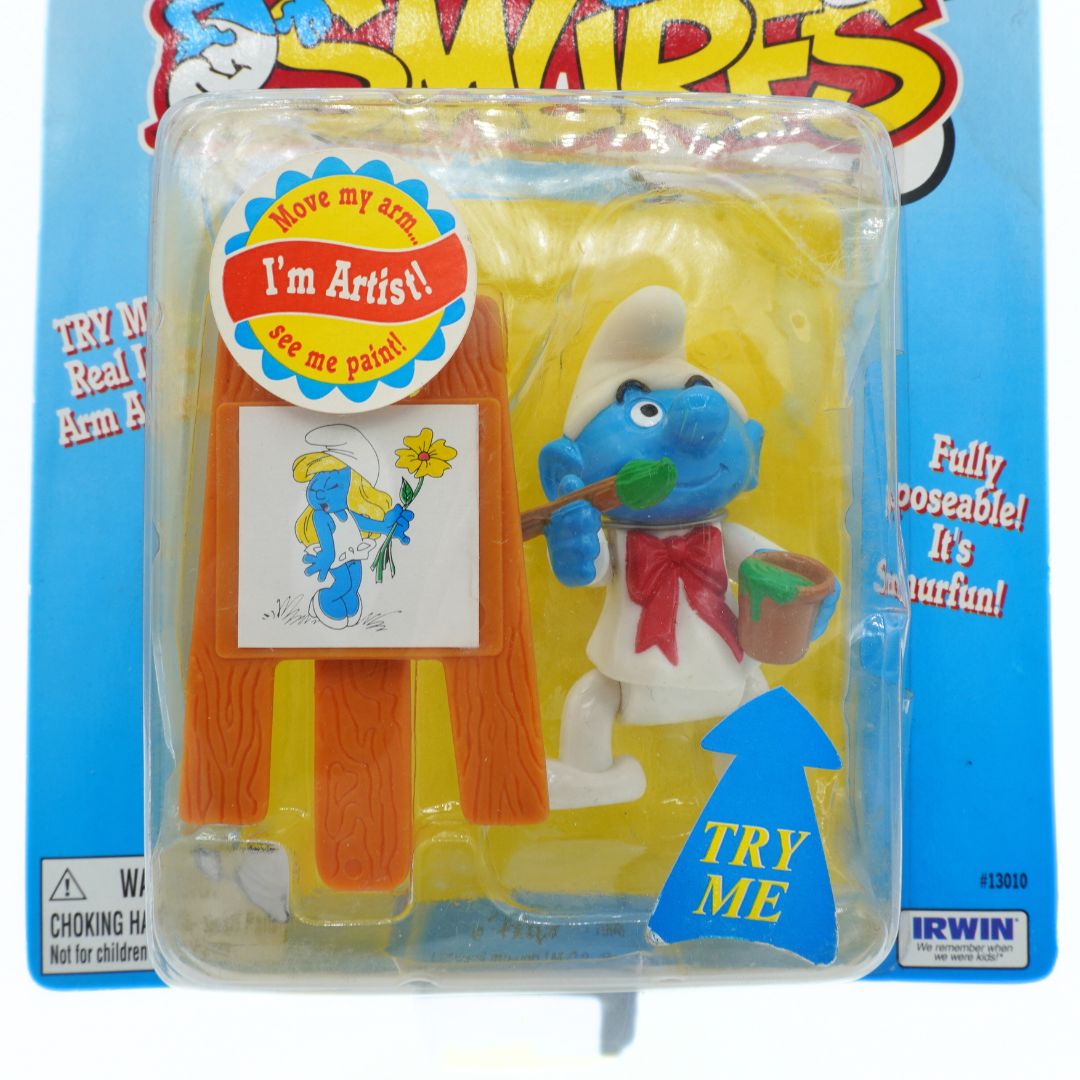 Toy figure in packaging with 'I'm Artist!' label against a blue background