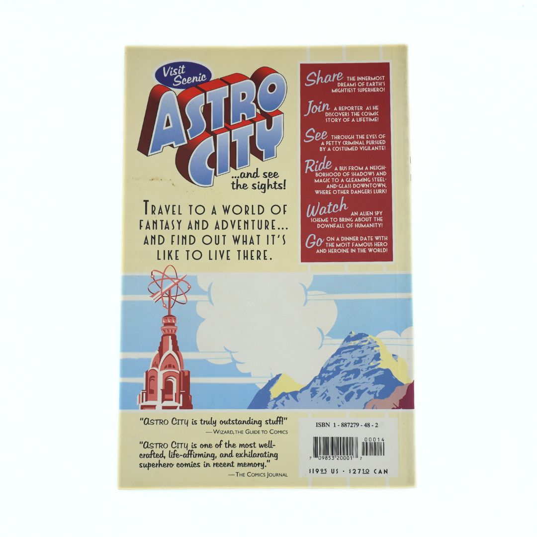 A retro-style book or magazine cover titled 'Astro City' with illustrated cover art, including a red church tower, blue sky, clouds, and mountains. The cover includes text blocks, a barcode, and a small 'Visit Scenic' logo.