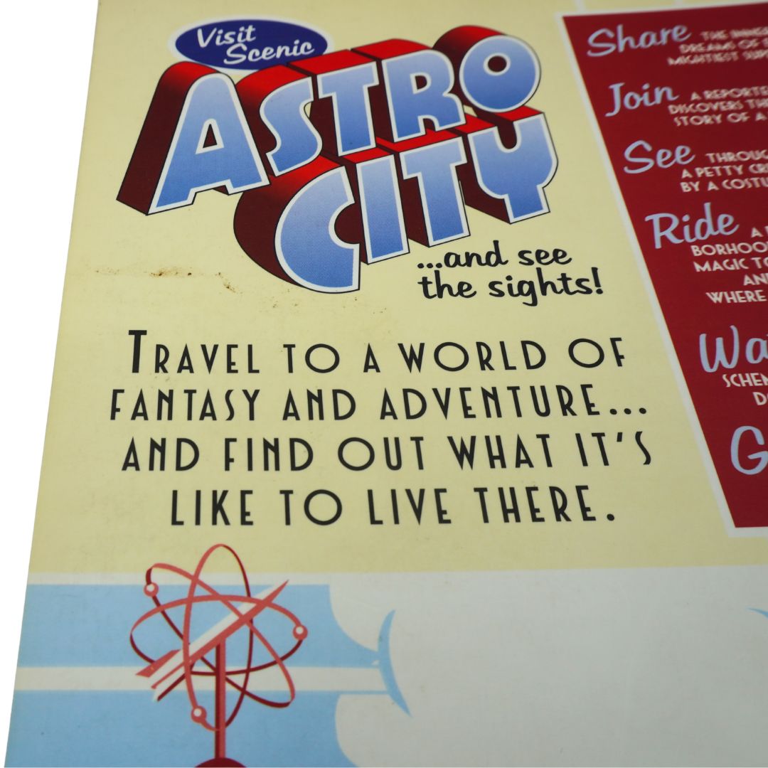 A close-up of a vintage-style poster or booklet page titled 'Astro City' with retro typography, promotional text, and a small atom illustration on a cream background.