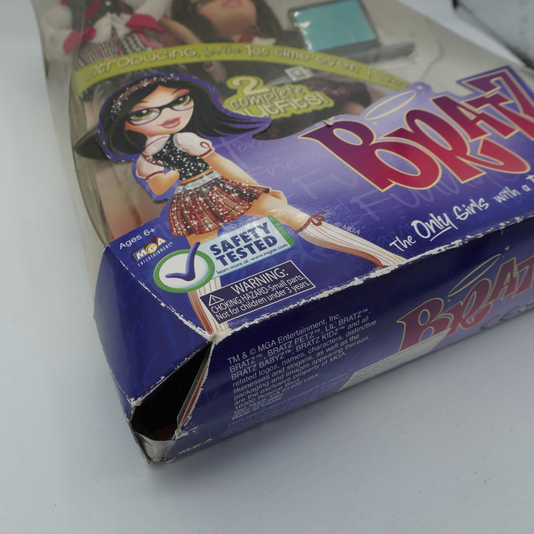A close-up of a worn Bratz toy packaging box on a white surface, showing the purple and pink box art with the Bratz logo and character illustration.