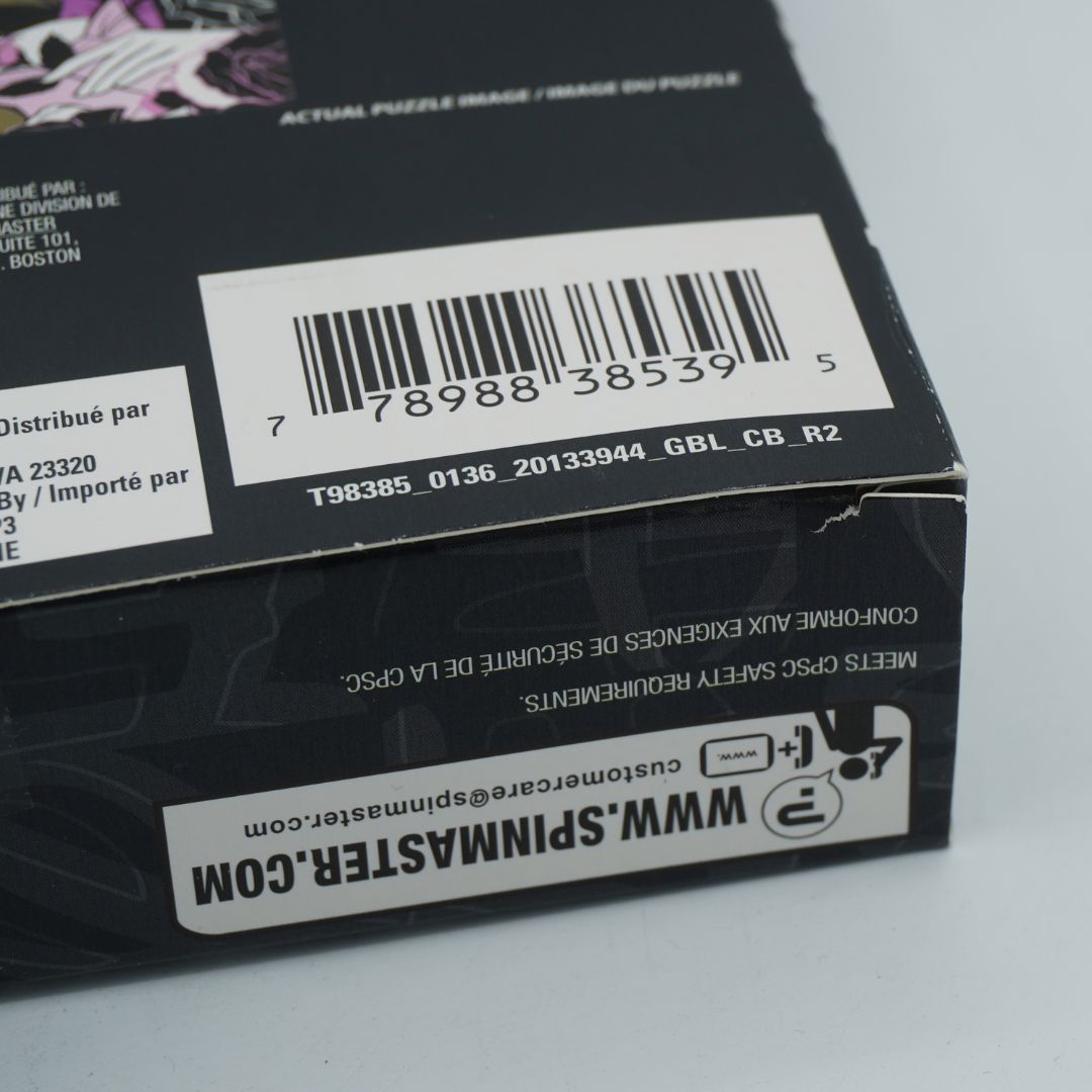 Close-up of a black product box showing a barcode, shipping labels, and the website www.spinmaster.com