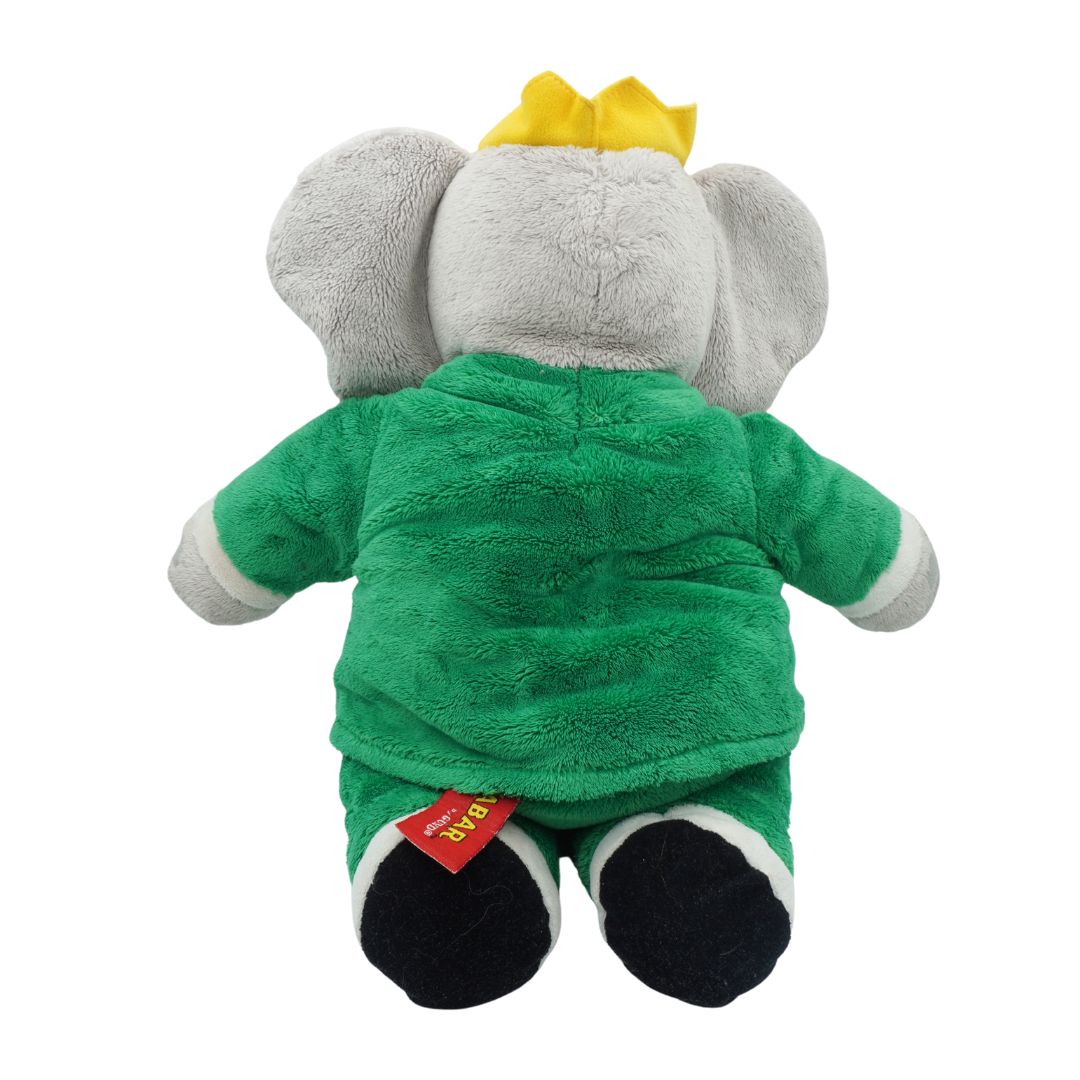 Plush elephant toy with a green outfit and yellow hat on a white background