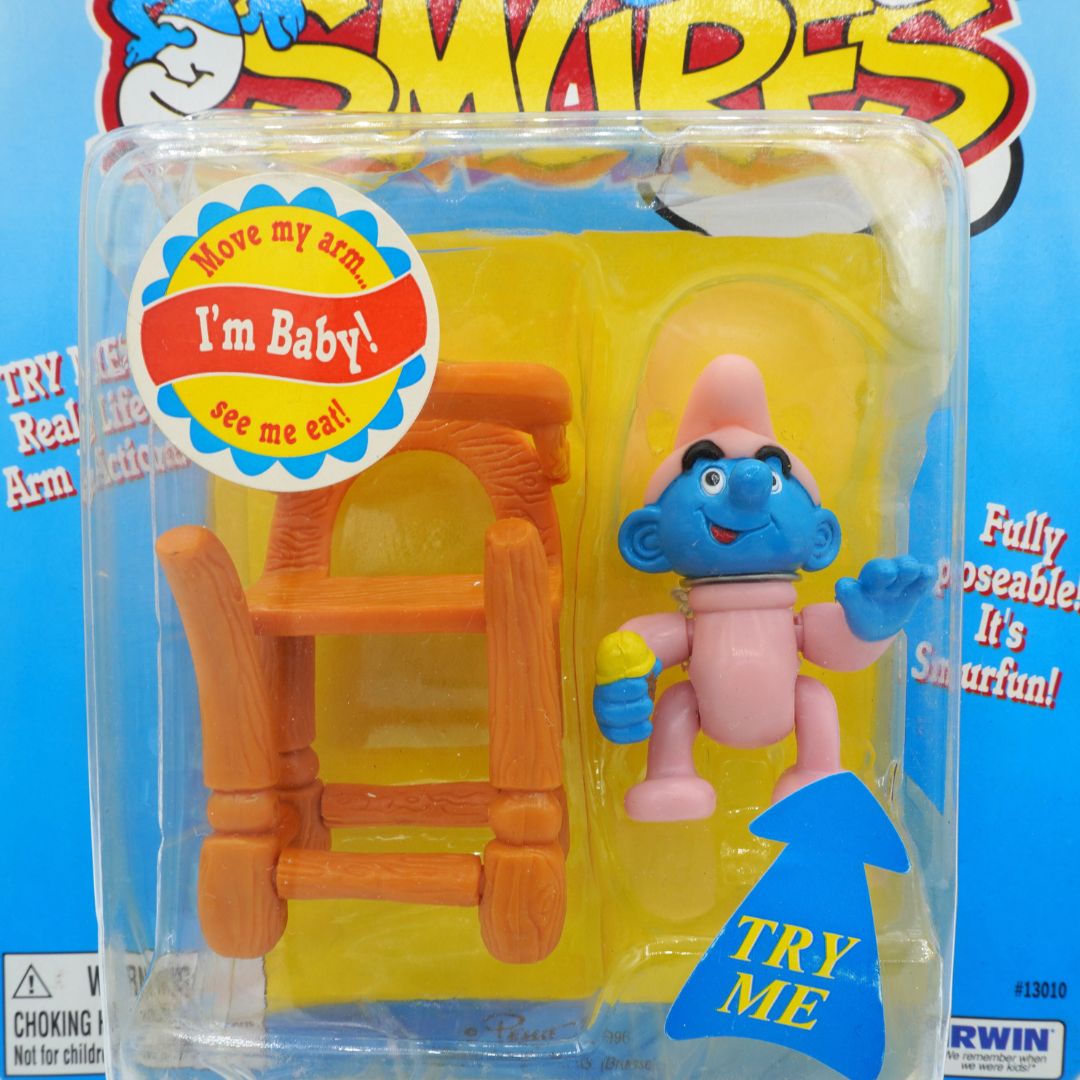 Toy figure in packaging with chair and 'I'm Baby!' label, against a blue background with 'Swipes' branding.