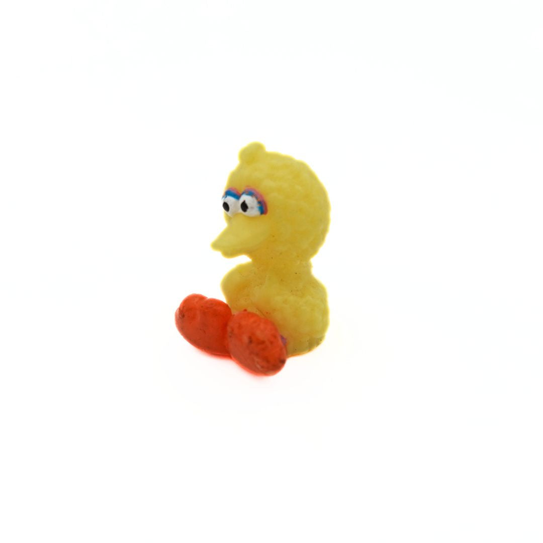 A mini baby Big Bird figurine, sitting down