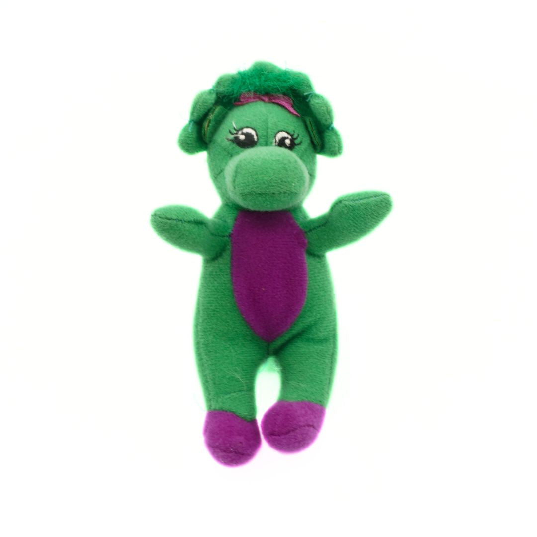 Green plush toy with purple accents on a white background