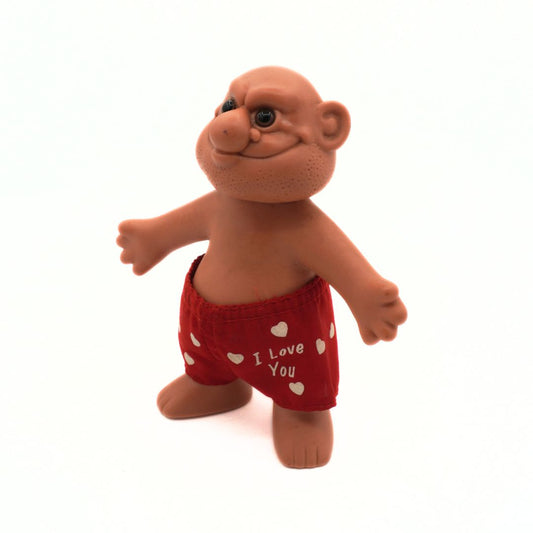 Small figurine wearing red shorts with 'I Love You' text on a white background