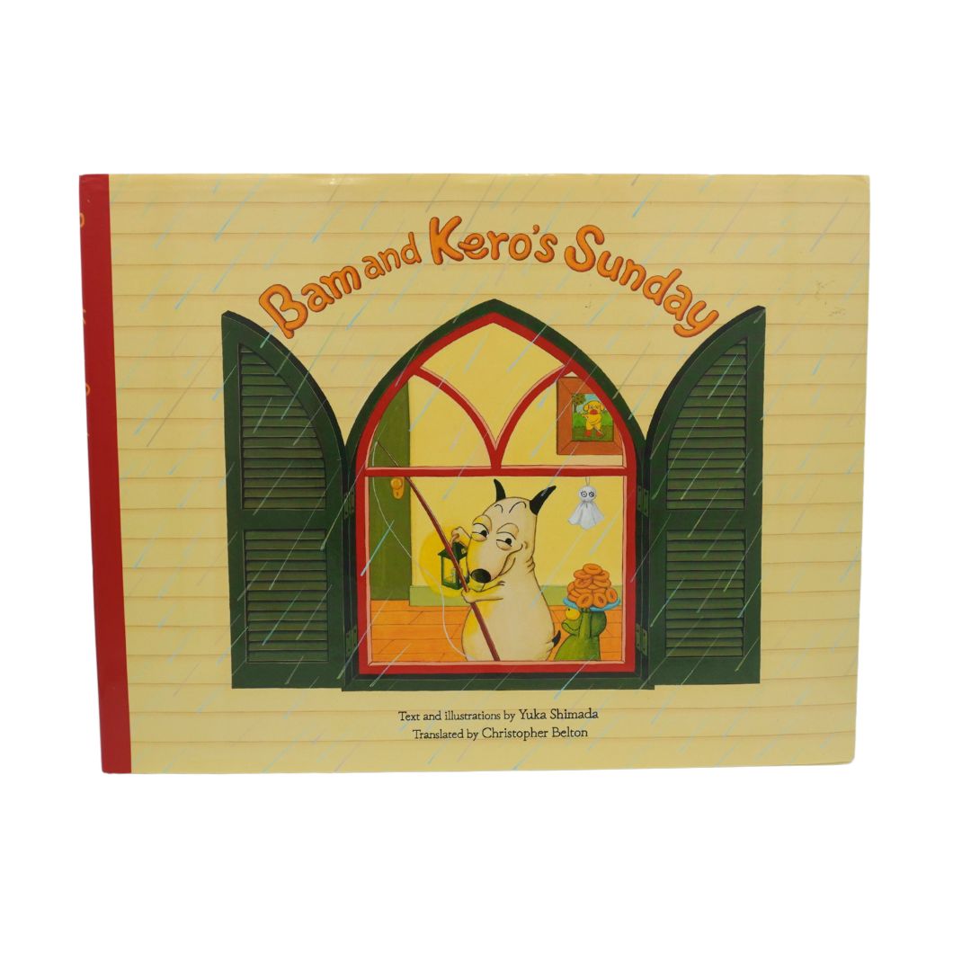 Children's picture book titled 'Bam and Kero's Sunday' with a cream-colored lined-paper cover design, featuring an illustration of a dog at an open window and a red spine band.