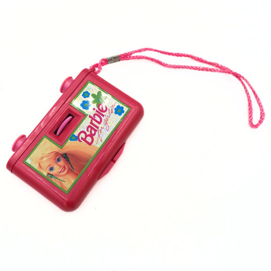 A pink Barbie-themed toy binoculars with a matching pink wrist strap, featuring a printed Barbie logo and illustration on the front, set against a plain white background.