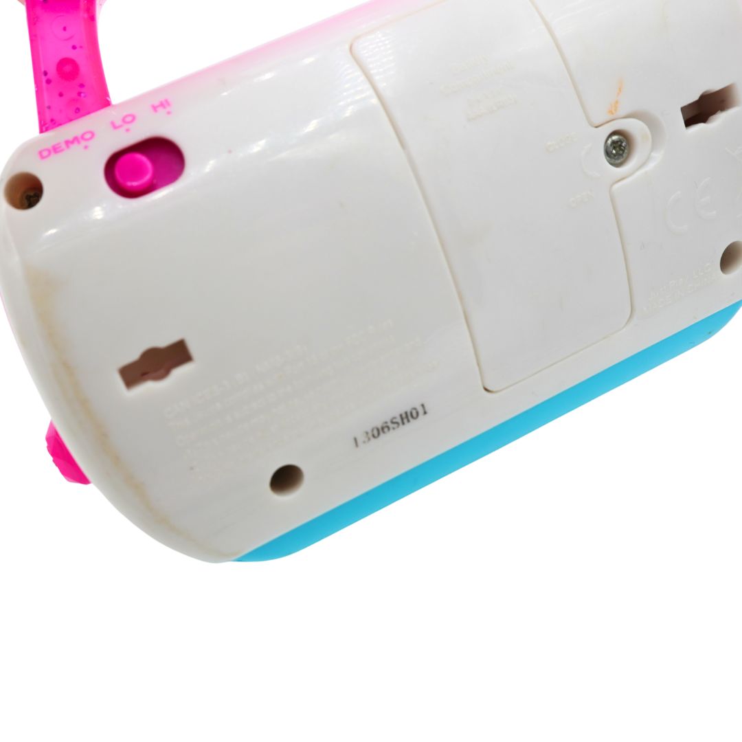 Close-up of the underside of a white handheld electronic device with a bright pink strap and a light blue edge, showing ports, screws, and printed markings on a white background.