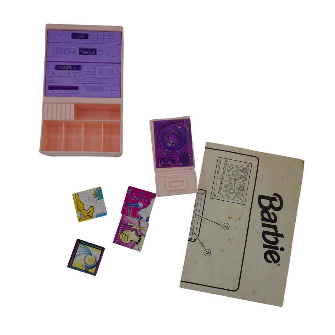 Vintage Barbie toy cassette radio set with its storage case, cassette player, instruction booklet, and two small accessory cards on a white background.