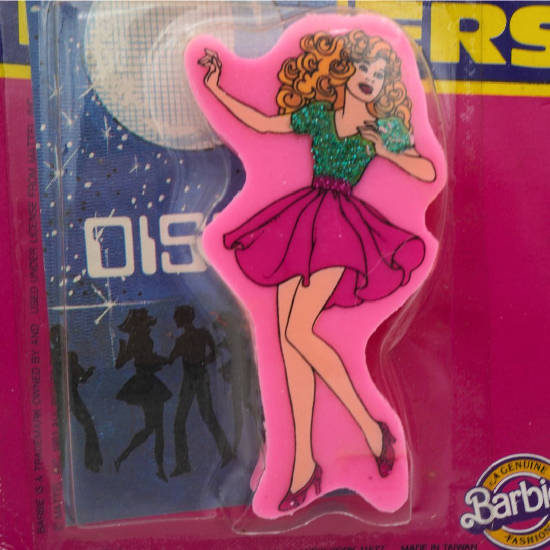 Vintage pink 1983 Barbie eraser with Barbie wearing a pink skirt and a sparkly green shirt