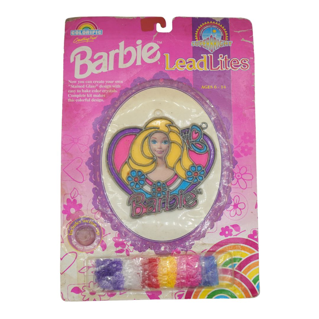 Barbie LeadLites coloring light kit in its original pink packaging, featuring a central oval light with Barbie graphics and a row of colorful lead light capsules at the bottom.