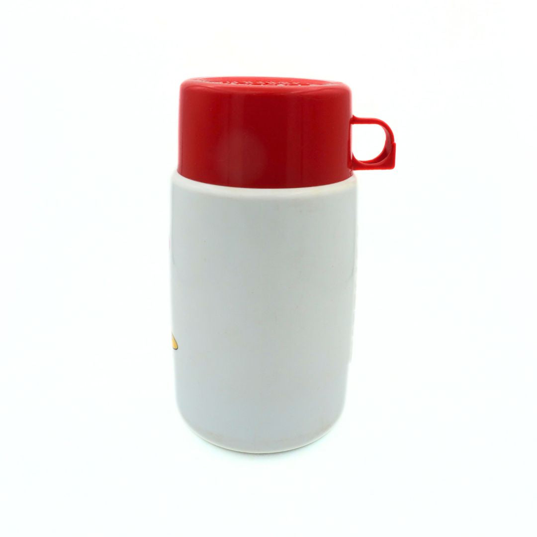 Side on photo of a 1990 Barbie thermos with a red lid