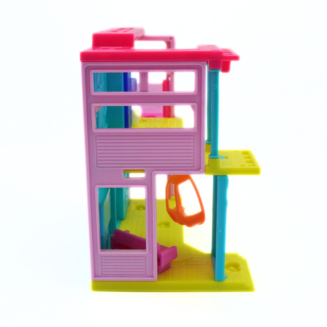 A colorful plastic toy building or playset with multiple levels, featuring pink, yellow, blue, and orange components on a plain white background.