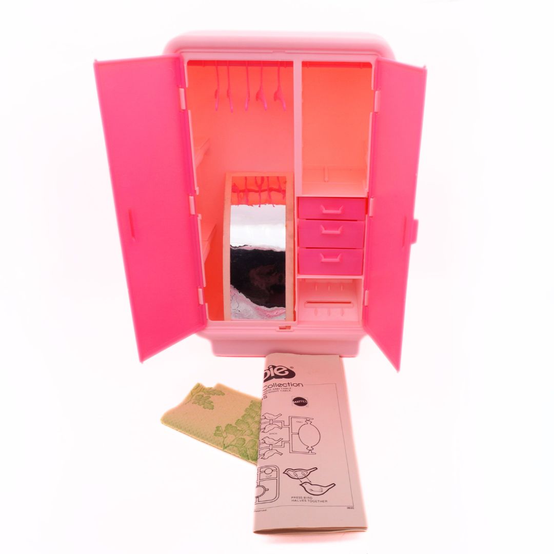 Pink toy wardrobe with open doors on a white background