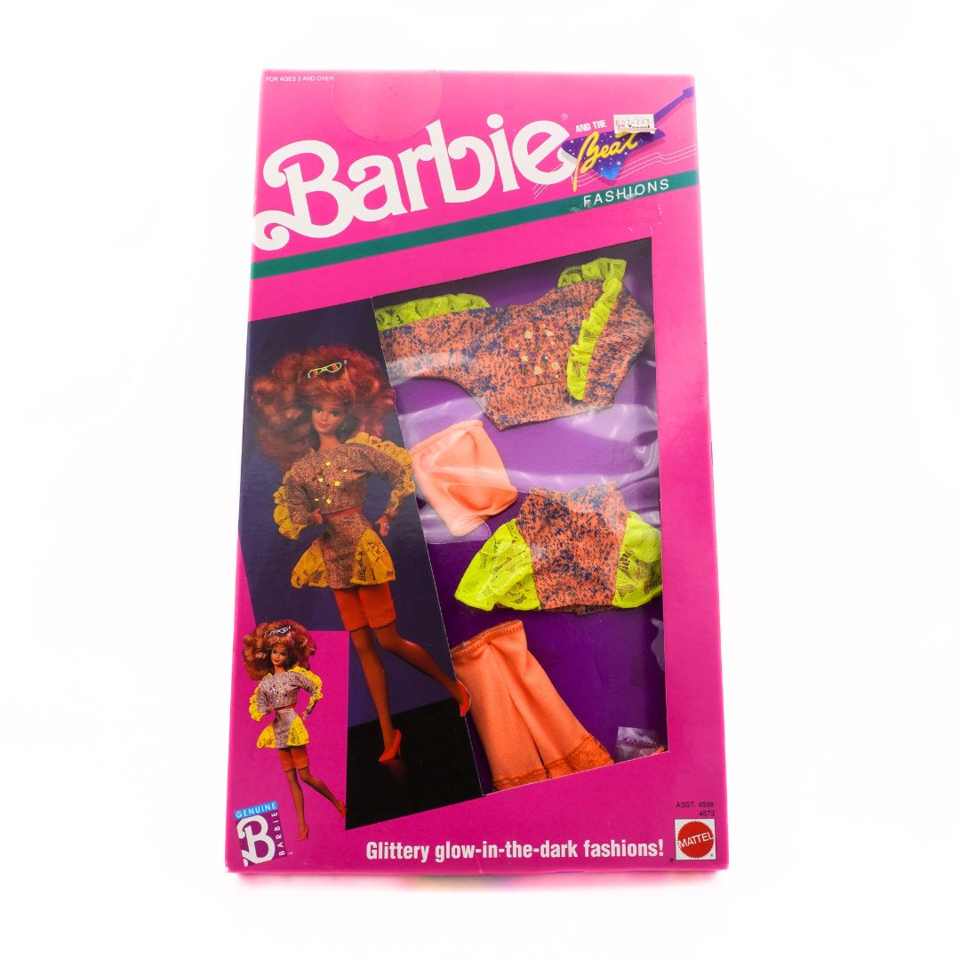 1989 Barbie fashion pack with colorful outfits on a pink background