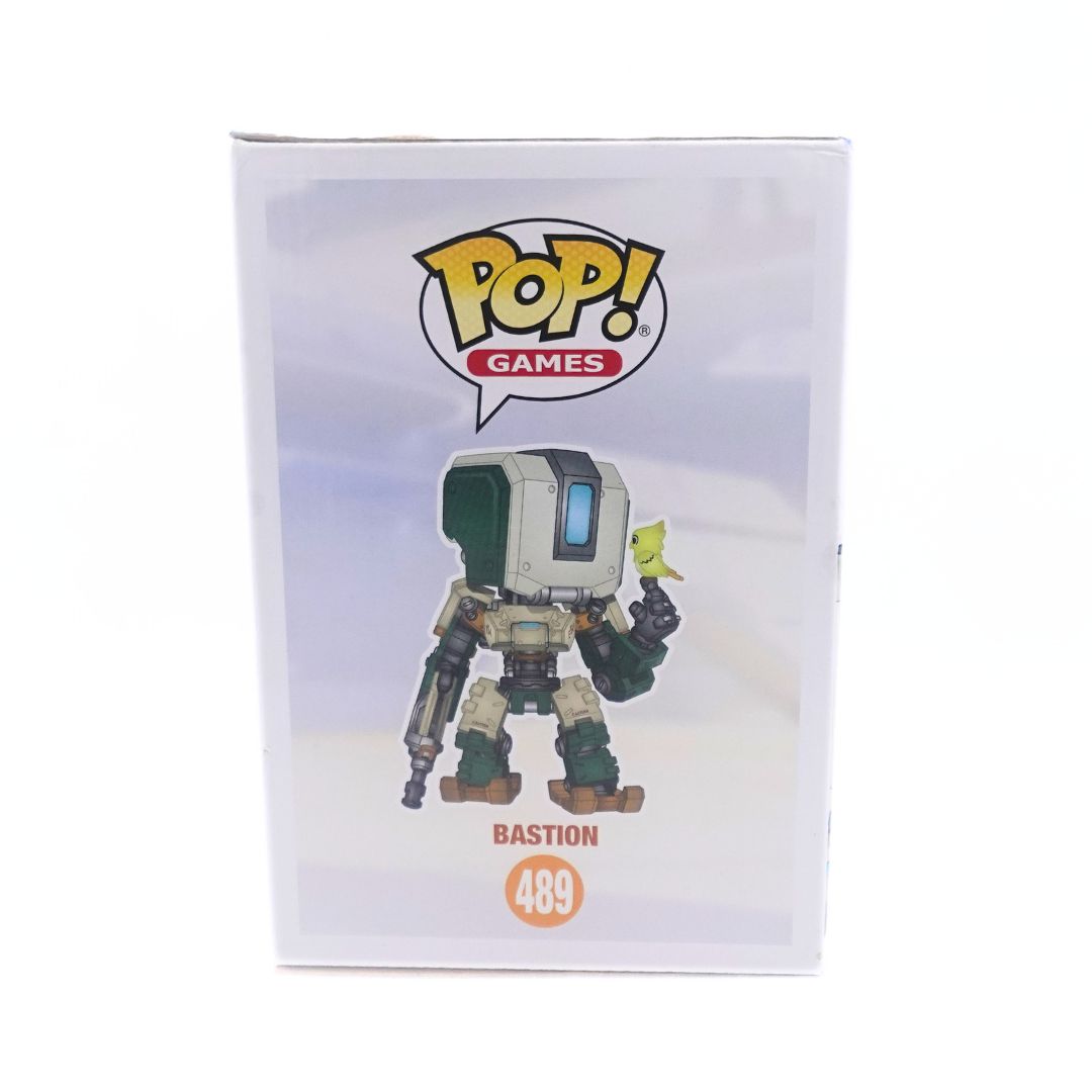 Side on photo of the Bastion large Pop Vinyl Funko Pop with an illustration of the design seen on the cardboard packagindg