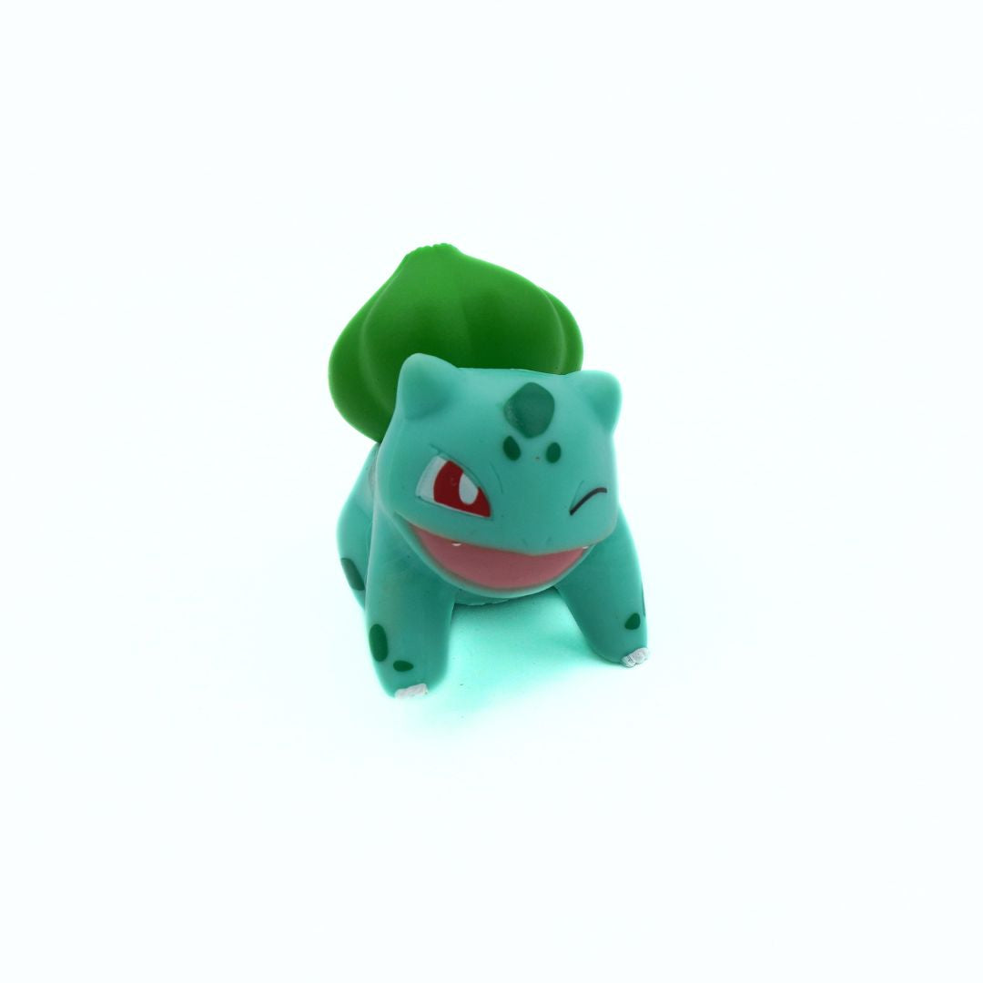 Plastic toy of a green creature with red tongue on a white background