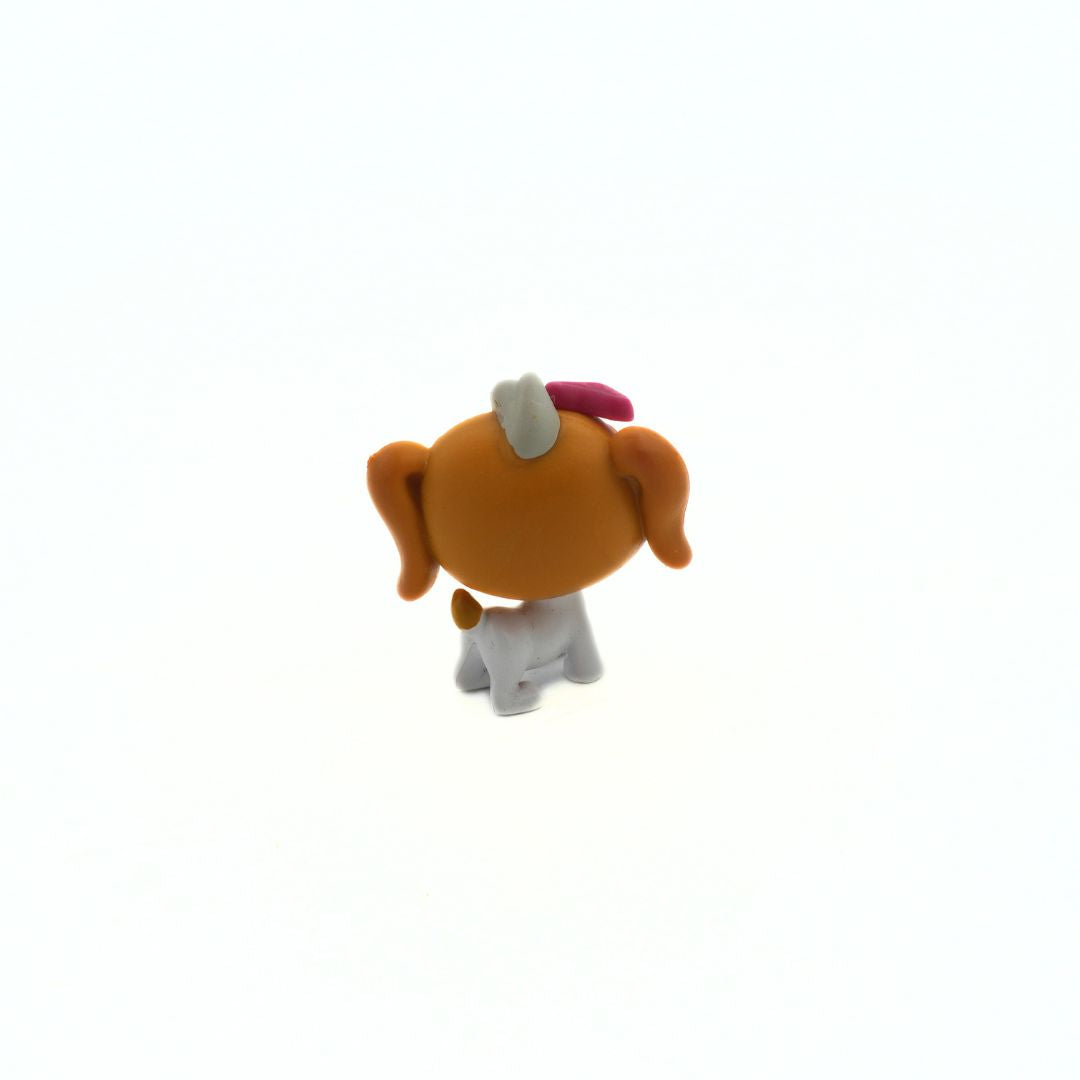 Small figurine of a dog with a pink bow on a white background