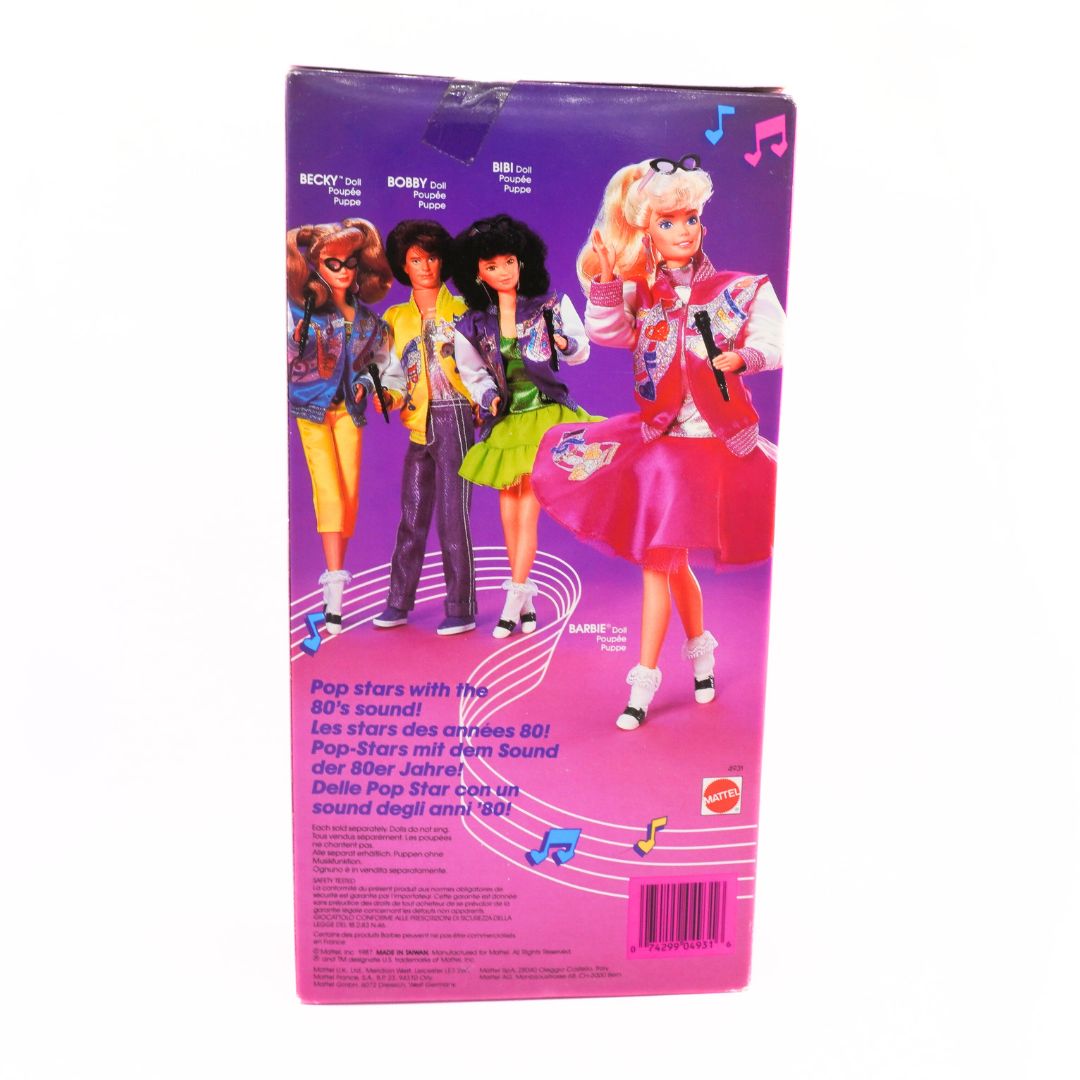 Barbie packaging with three dolls on a purple and pink background