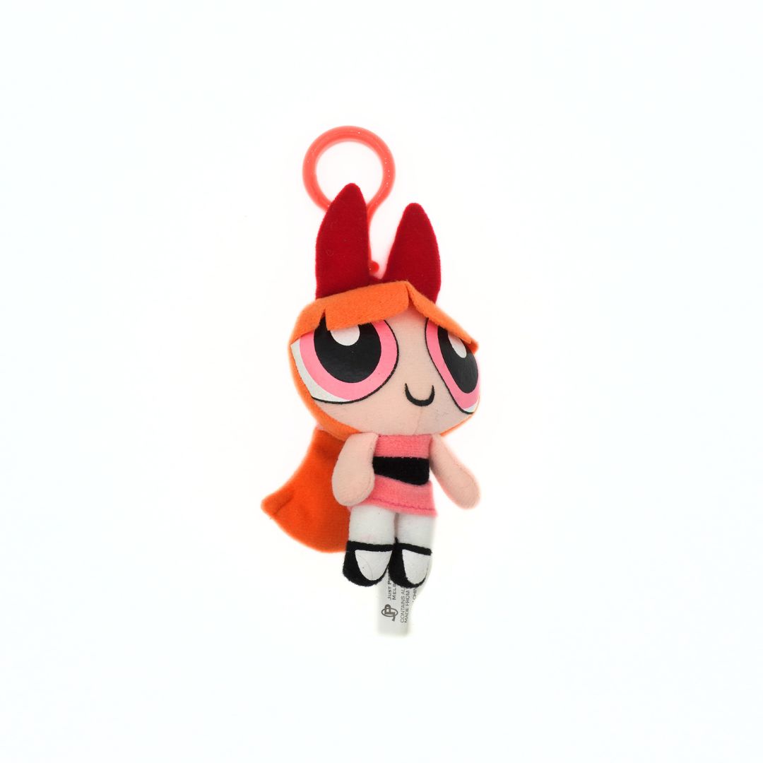 Plush toy keychain with a character wearing a red cape and hat on a white background