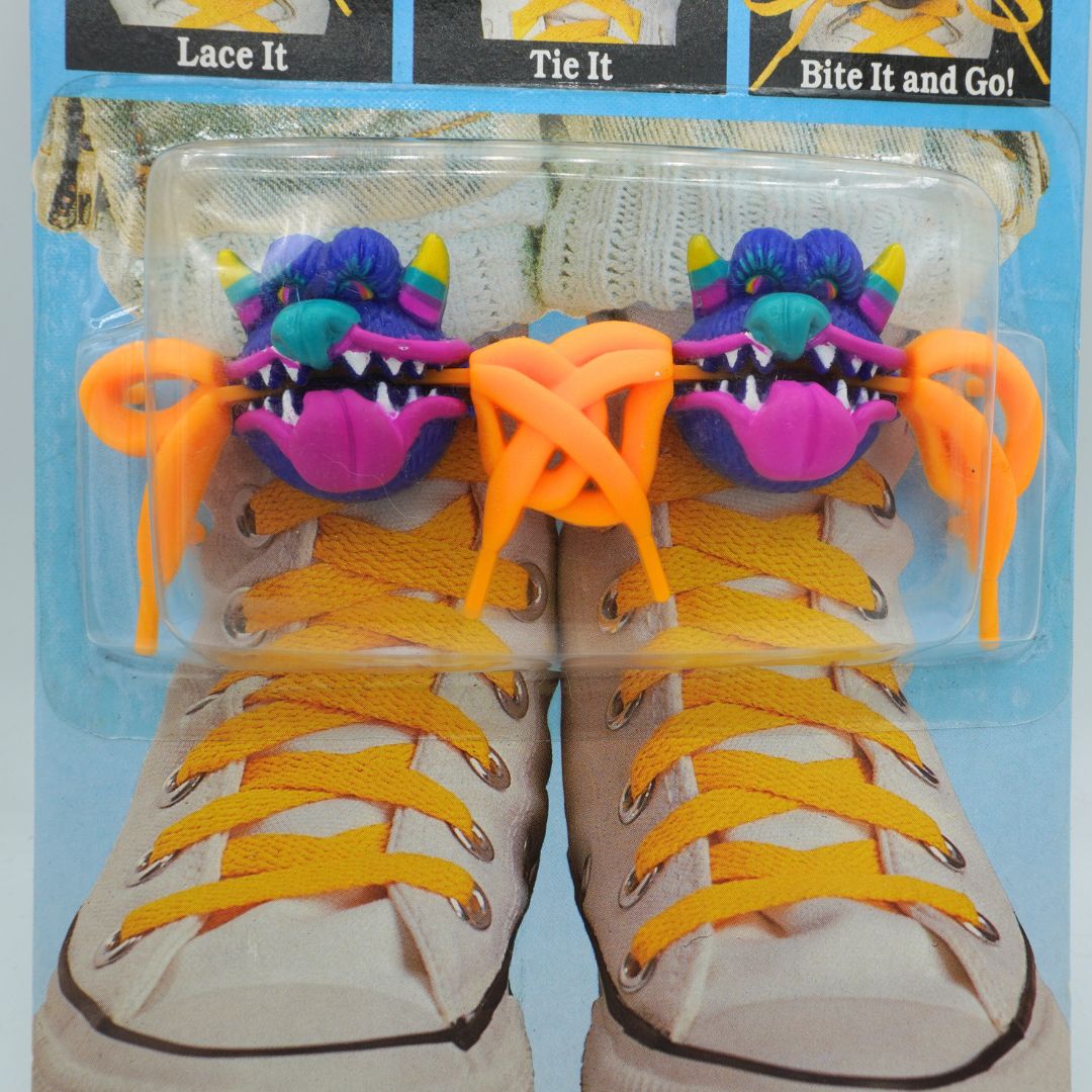 Shoe laces with colorful dragon-shaped lace ends on a packaging background