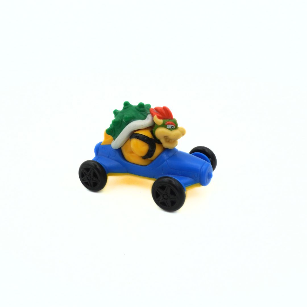 Toy car with a character wearing a green hat and red bow on a white background