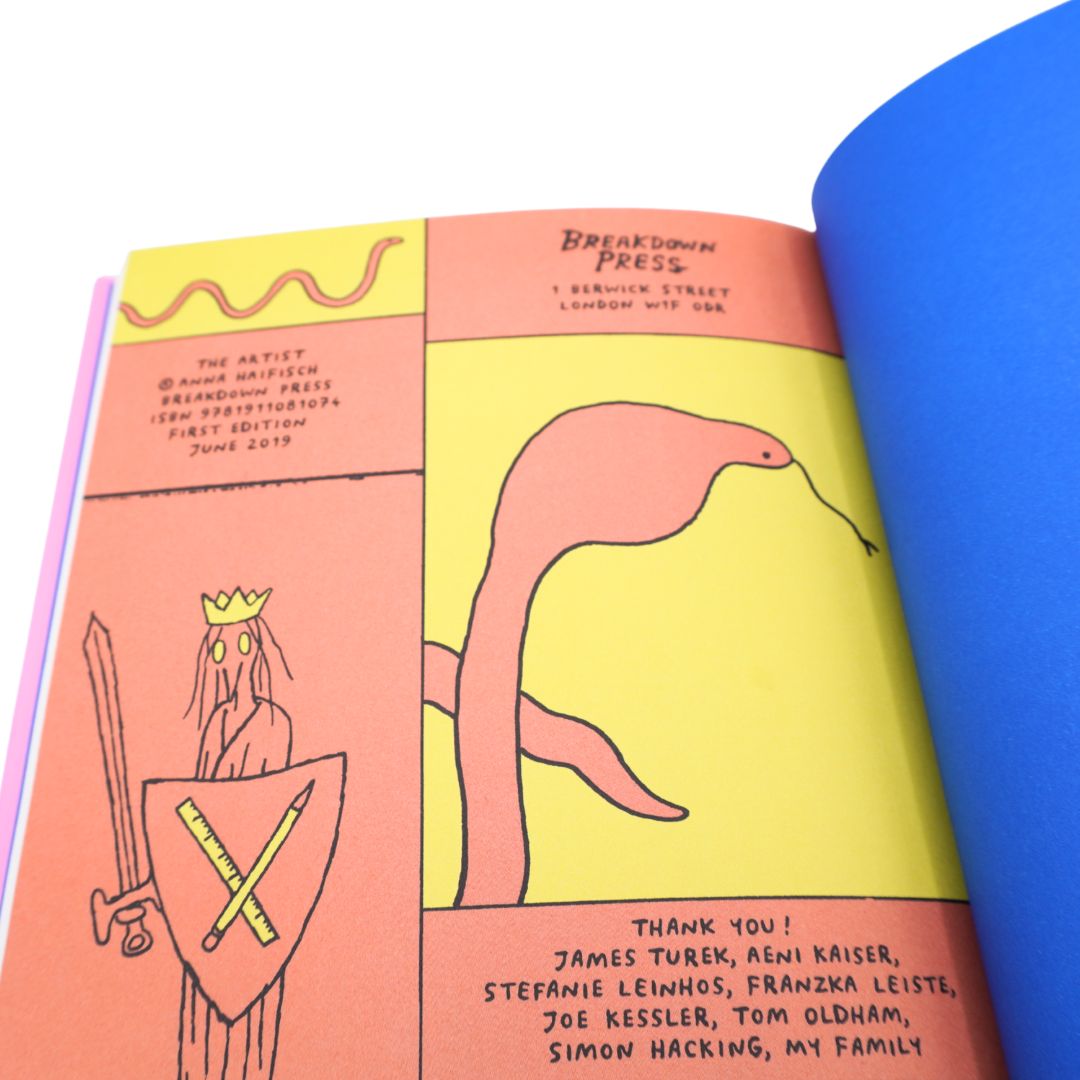 An open art book or magazine spread showing two illustrated pages with a yellow and peach background, a snake drawing, and printed text including 'Breakdown Press' and a thank-you note. A bright blue page or sheet is visible on the right.